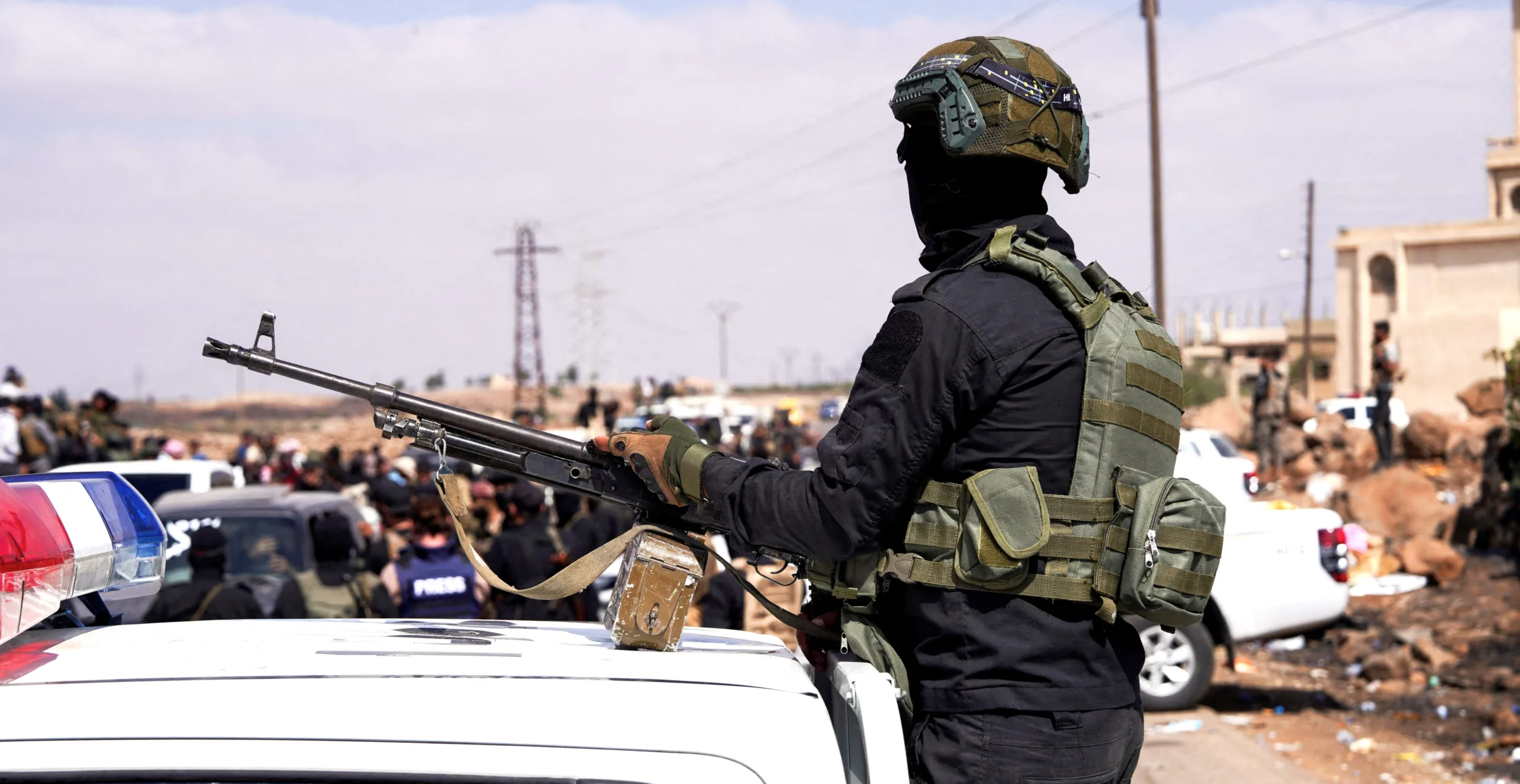 جندي مسلح يقف على مركبة أمنية في موقع ميداني