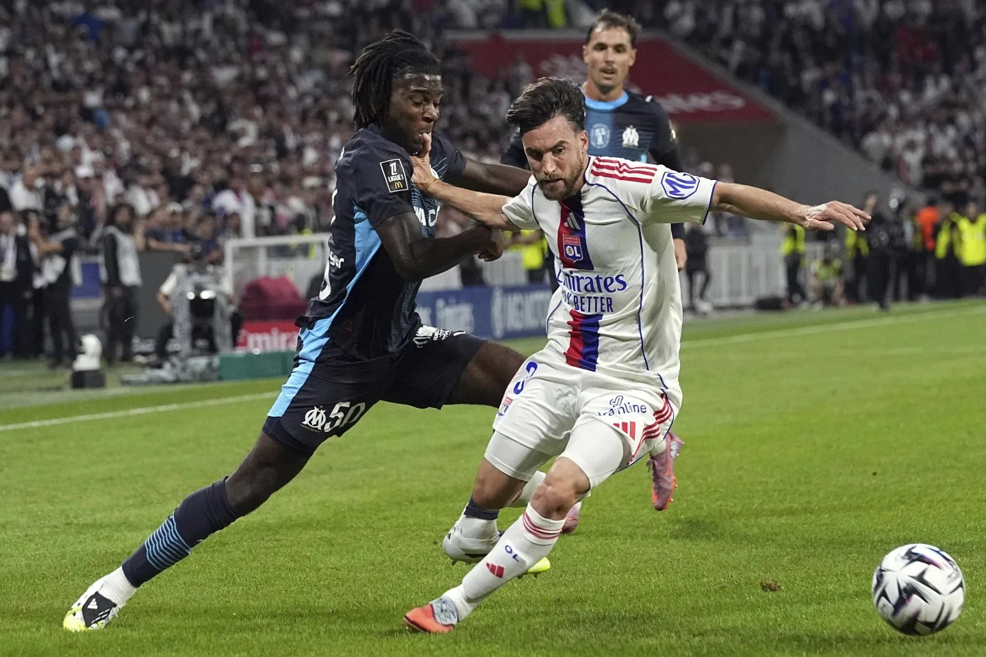 لاعب ليون يراوغ مدافع مرسيليا خلال مباراة الدوري الفرنسي
