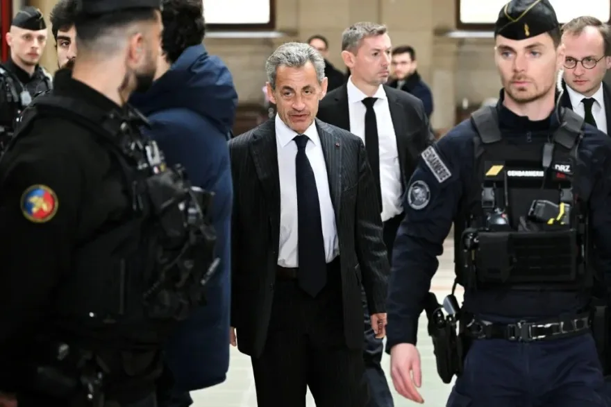 نيكولا ساركوزي محاطاً بضباط الشرطة الفرنسية داخل قاعة المحكمة