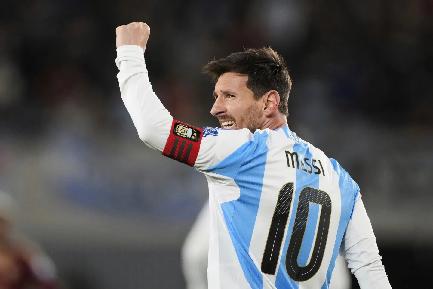 ليونيل ميسي يرفع قبضته احتفالاً ترتدي قميص منتخب الأرجنتين الأزرق والأبيض برقم 10 مع كابتن