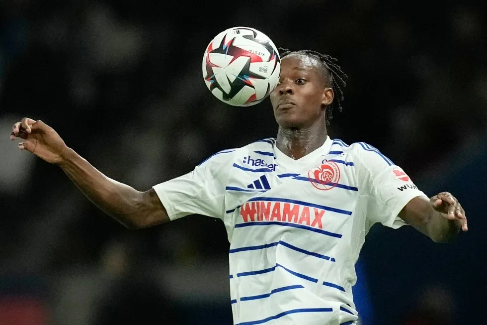 إيمانويل إيمغا لاعب كرة القدم الهولندي الشاب يرتدي قميص فريق في اللون الأبيض يسيطر على الكرة بمهارة احترافية