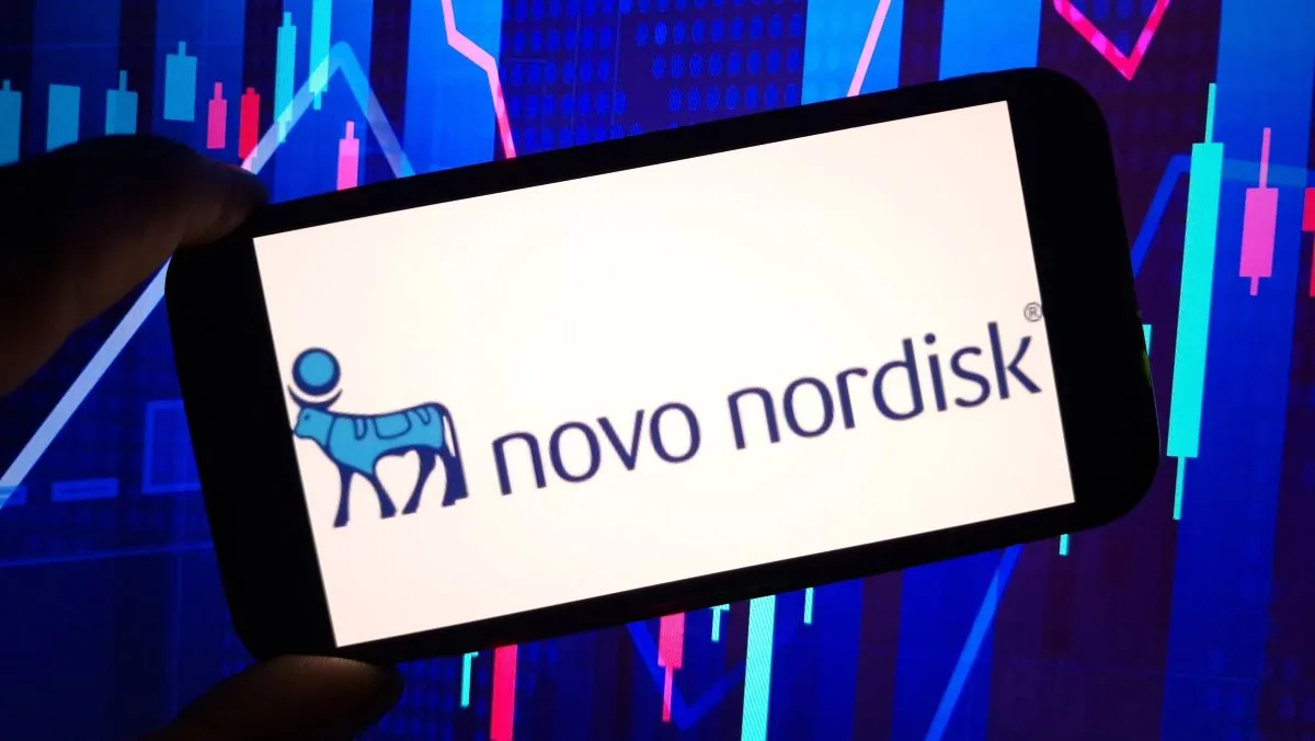 شعار نوفو نورديسك على هاتف ذكي مع خلفية رسوم بيانية لتراجع أسهم الشركة