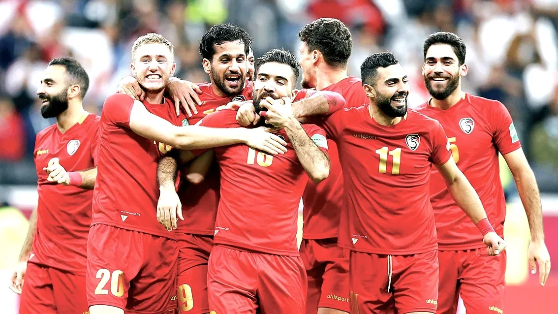 لاعبو منتخب سوريا لكرة القدم يحتفلون بهدف في المباراة بقمصان حمراء