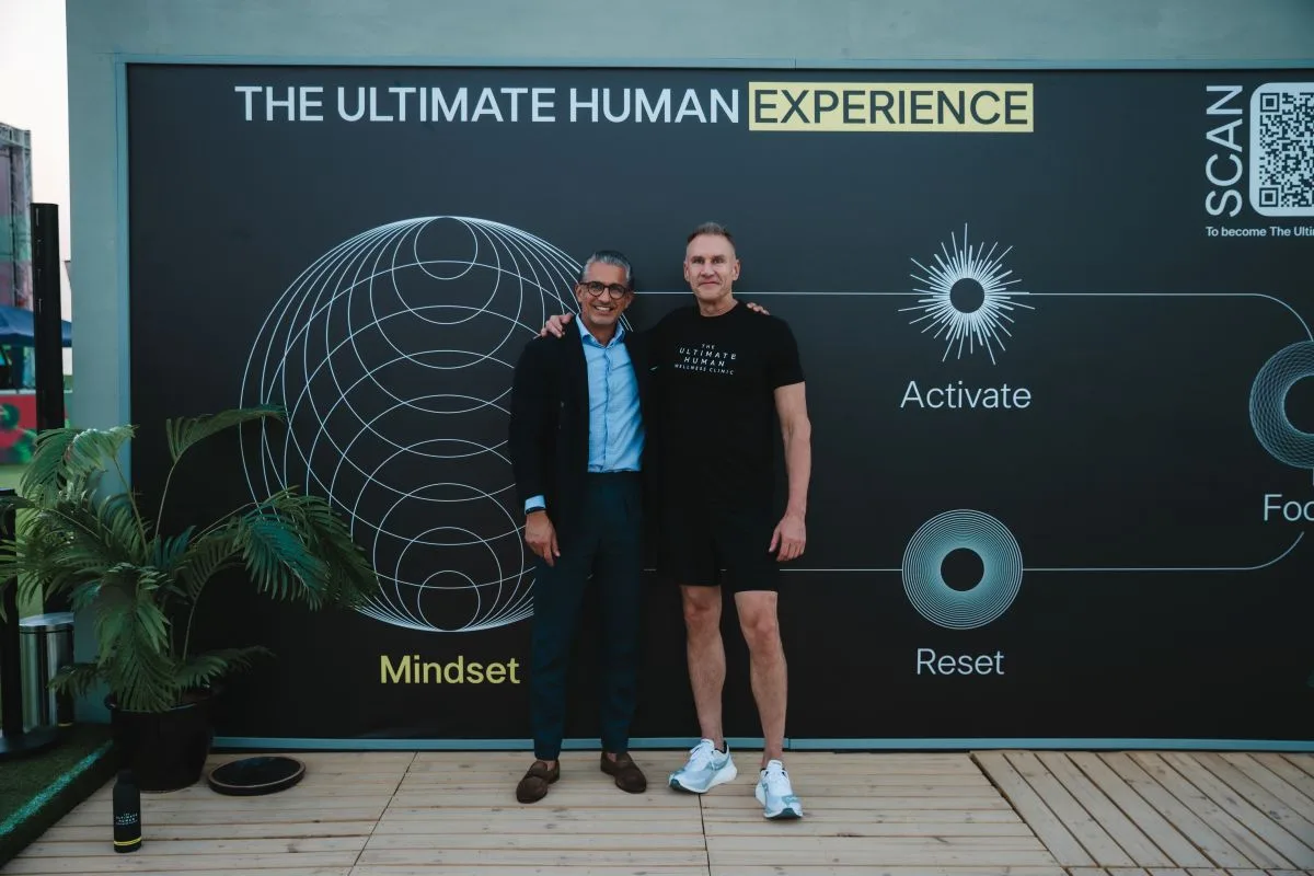 مؤسس ذا ثيمد هيومان وممثل من المجموعة القابضة يقفان أمام لافتة تحمل شعار التجربة الصحية بمناطقها الأربع