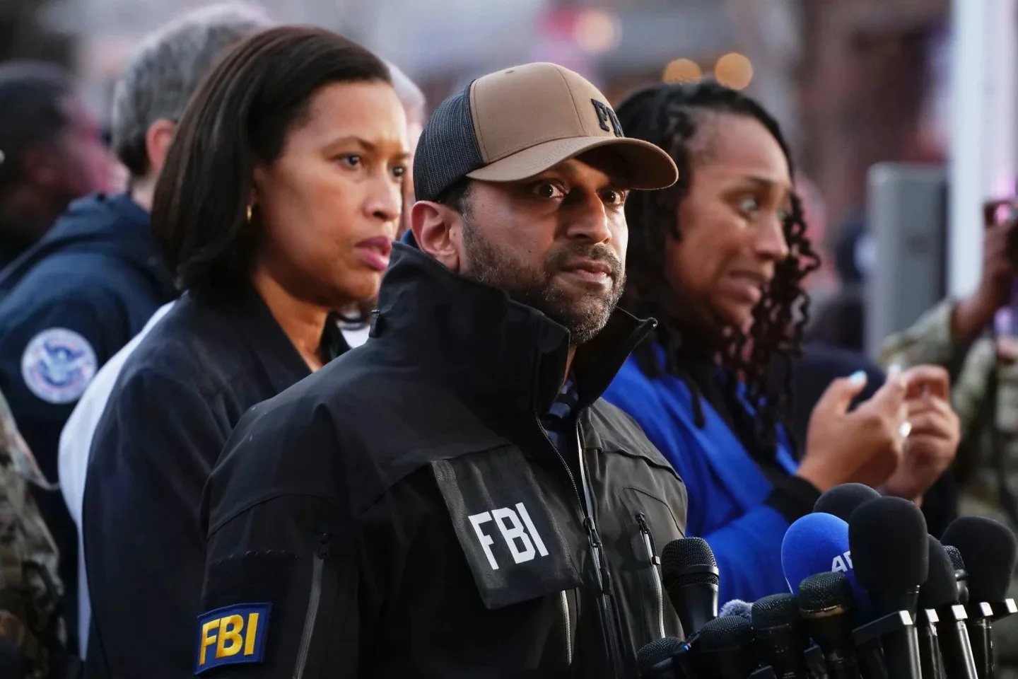 كاش باتيل يتحدث في مؤتمر صحفي أمام ميكروفونات على منصة رسمية