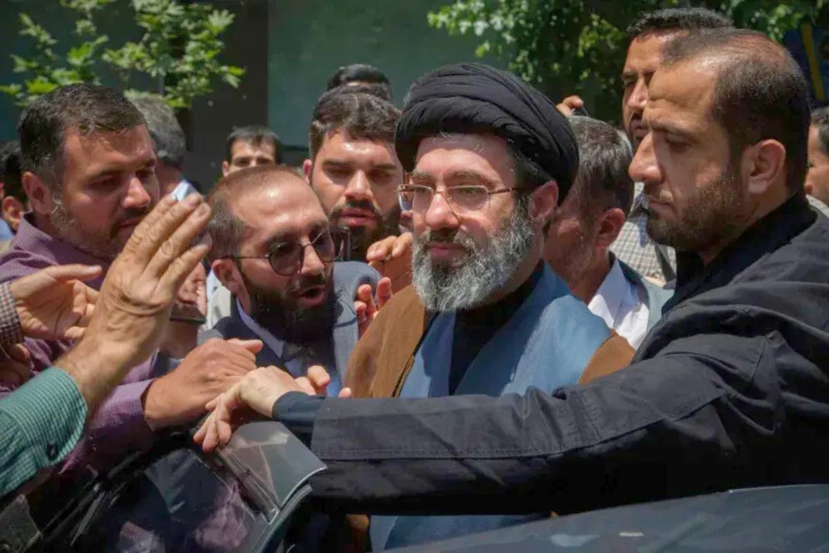 رجل دين يرتدي عمامة سوداء ونظارات وسط حشد من الناس